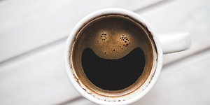 En kopp kaffe som efterliknar en glad smiley